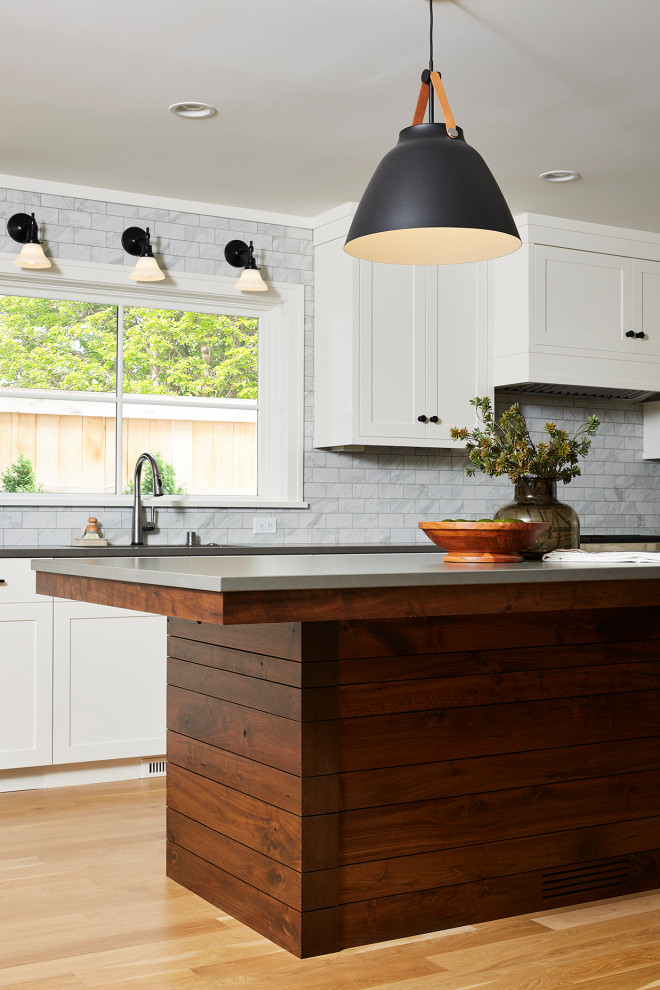 Inspiration for a transitional l-shaped kitchen in Minneapolis with shaker cabinets, white cabinets, grey splashback, subway tile splashback, stainless steel appliances, medium hardwood floors, with island and grey benchtop.