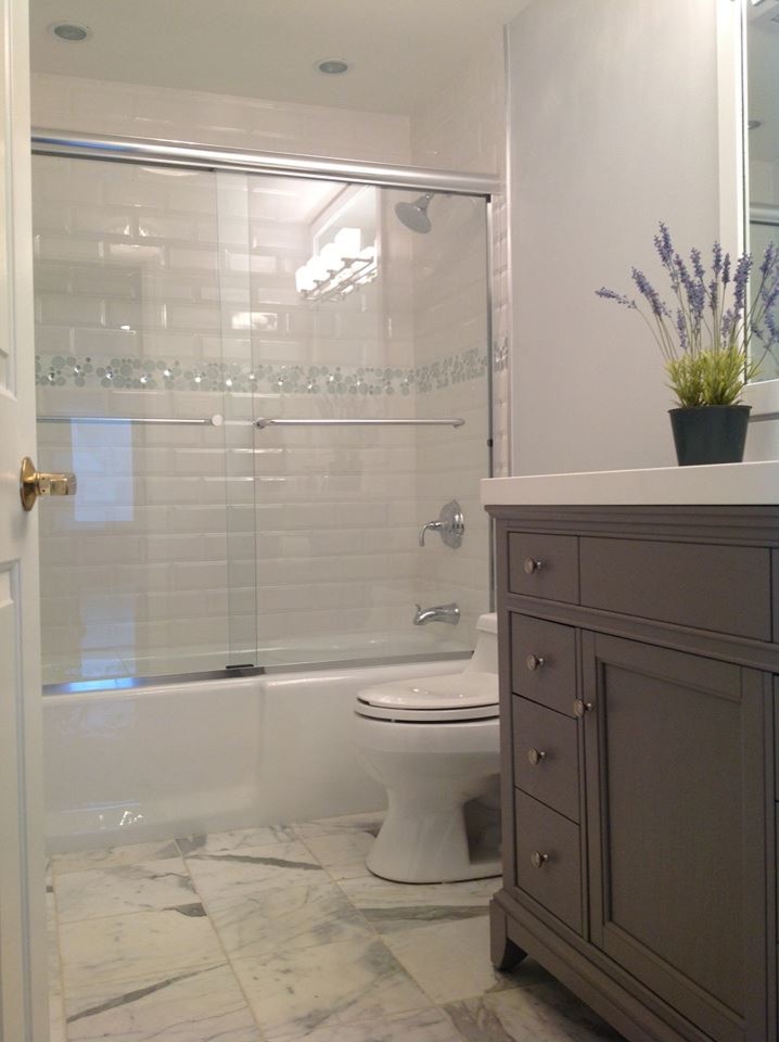 Inspiration for a mid-sized transitional multicolored tile and subway tile marble floor alcove bathtub remodel with an undermount sink, recessed-panel cabinets, gray cabinets, quartz countertops, a one-piece toilet and gray walls
