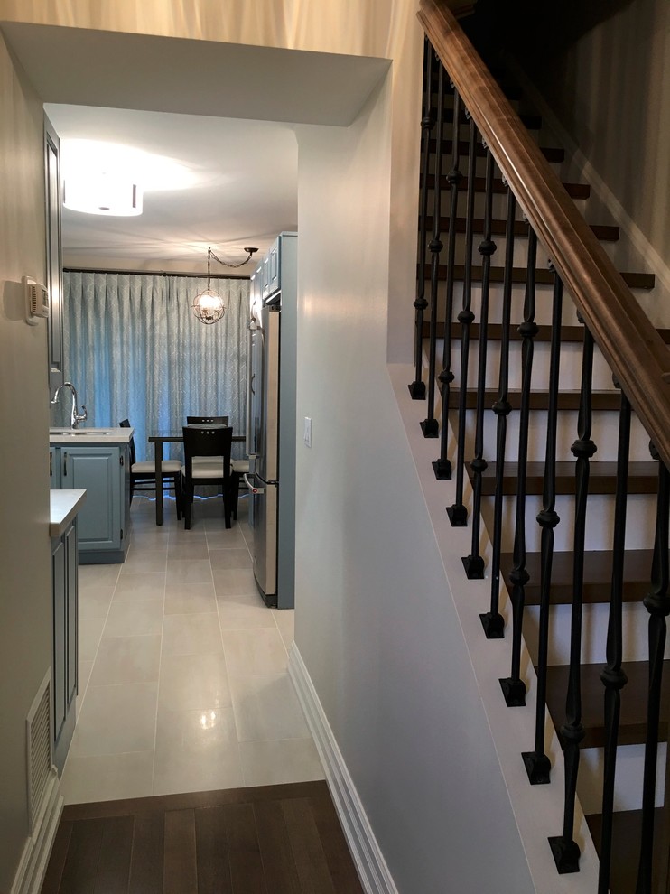 Example of a transitional u-shaped porcelain tile enclosed kitchen design in Toronto with an undermount sink, quartz countertops and white backsplash