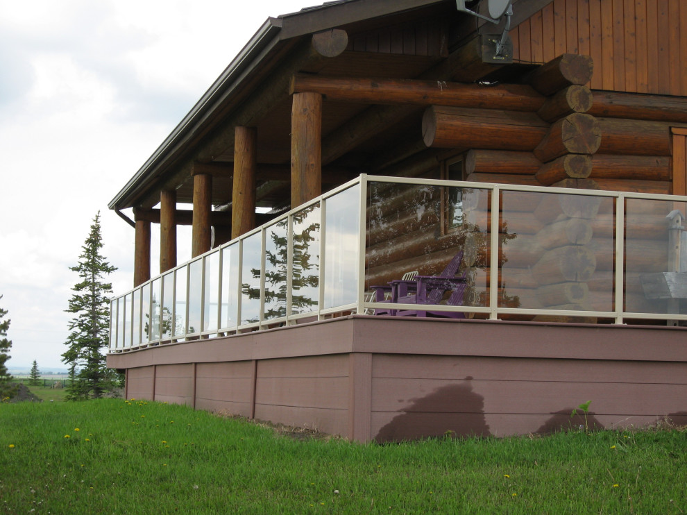 Inspiration for a huge rustic backyard privacy deck remodel in Calgary with a roof extension