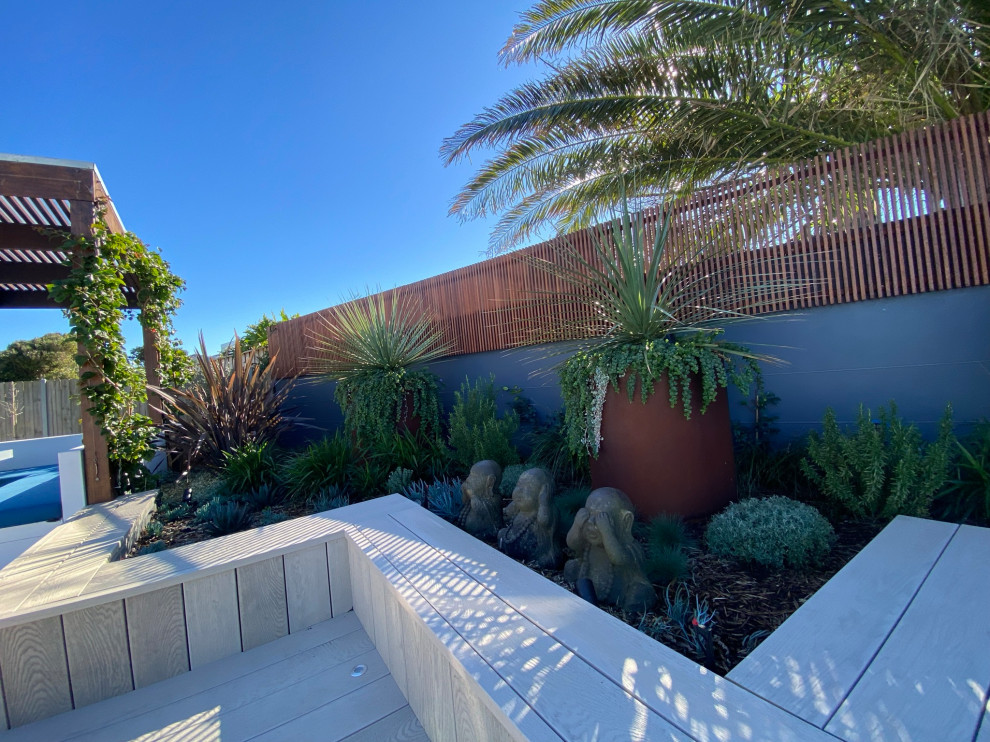 Idee per un giardino minimalista esposto in pieno sole di medie dimensioni e dietro casa con pedane e recinzione in legno