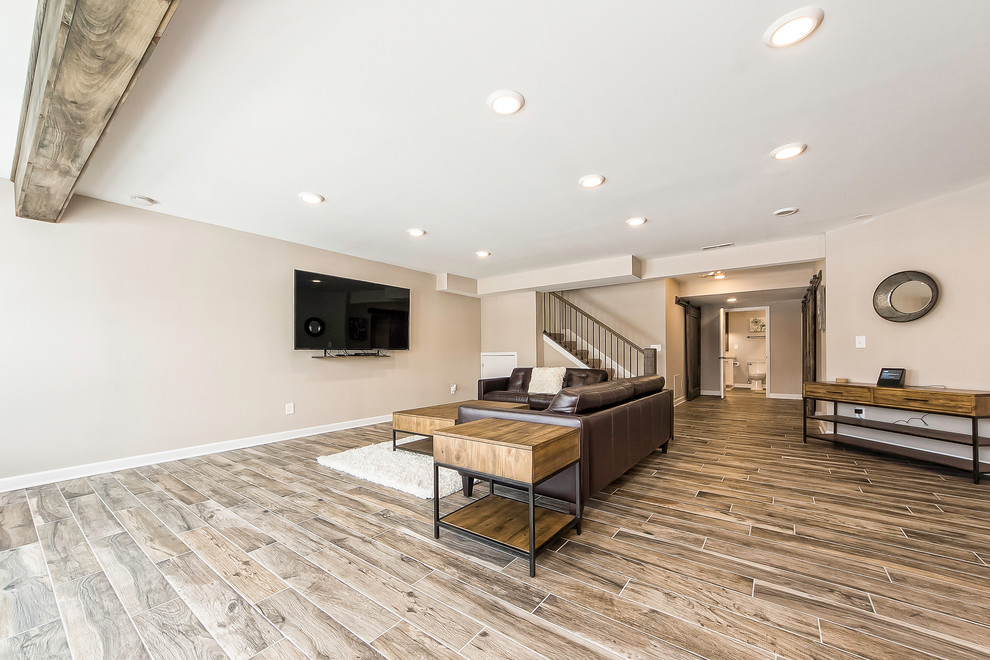 Example of a mid-sized mountain style look-out porcelain tile and brown floor basement design in Columbus with beige walls and no fireplace