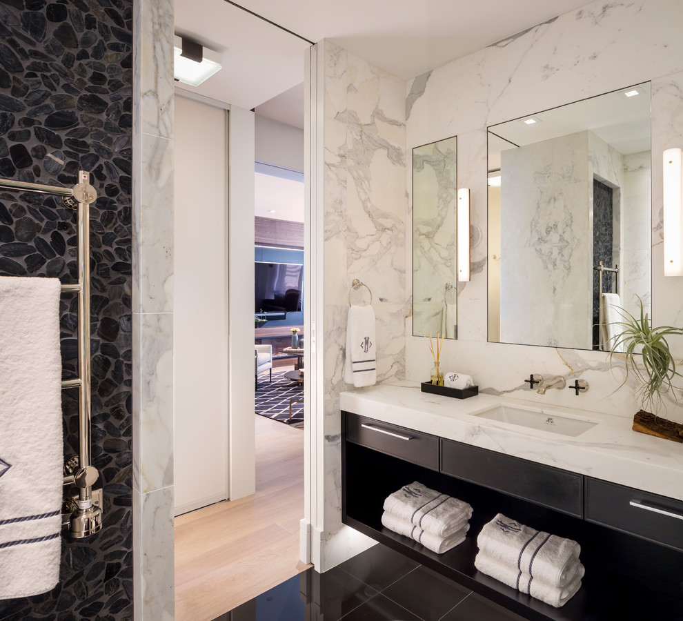 Contemporary bathroom in San Francisco with flat-panel cabinets, black cabinets, black tile, gray tile, white tile, pebble tile, white walls, an undermount sink, marble benchtops, black floor and white benchtops.