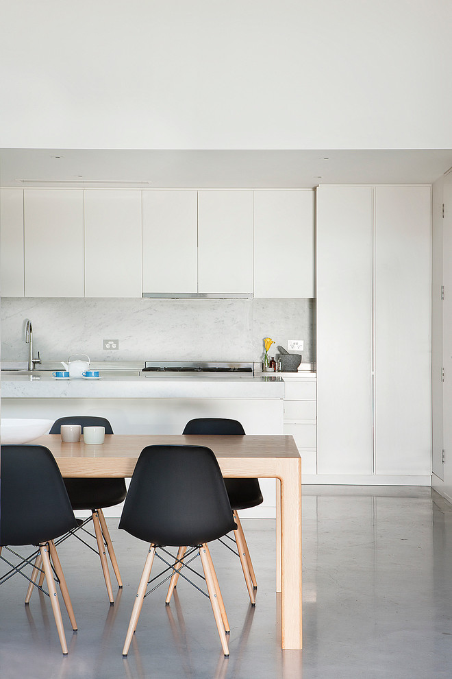 Design ideas for a contemporary galley kitchen in Melbourne with flat-panel cabinets, white cabinets and concrete floors.