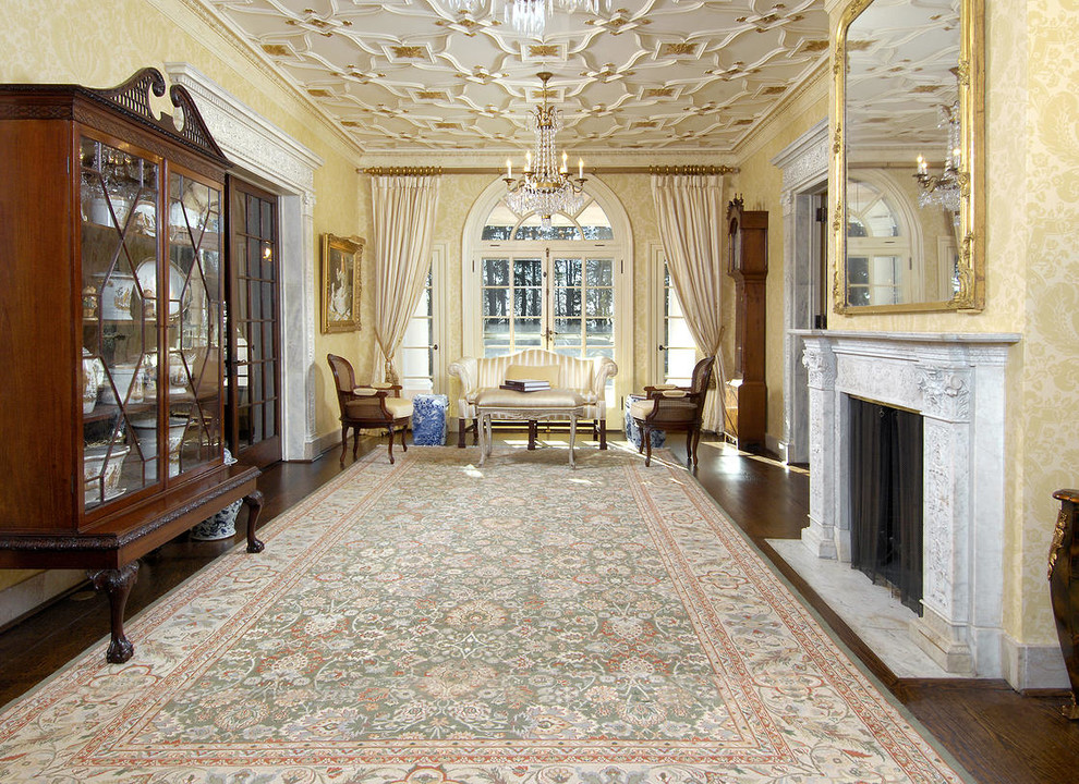 Expansive traditional formal enclosed living room in New York with yellow walls, dark hardwood floors, a standard fireplace, a plaster fireplace surround and no tv.