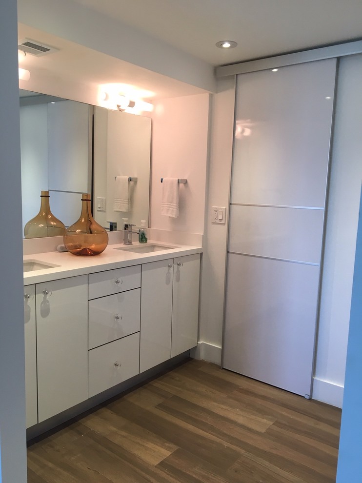Wood look porcelain floors, white vanity and high gloss barn doors.