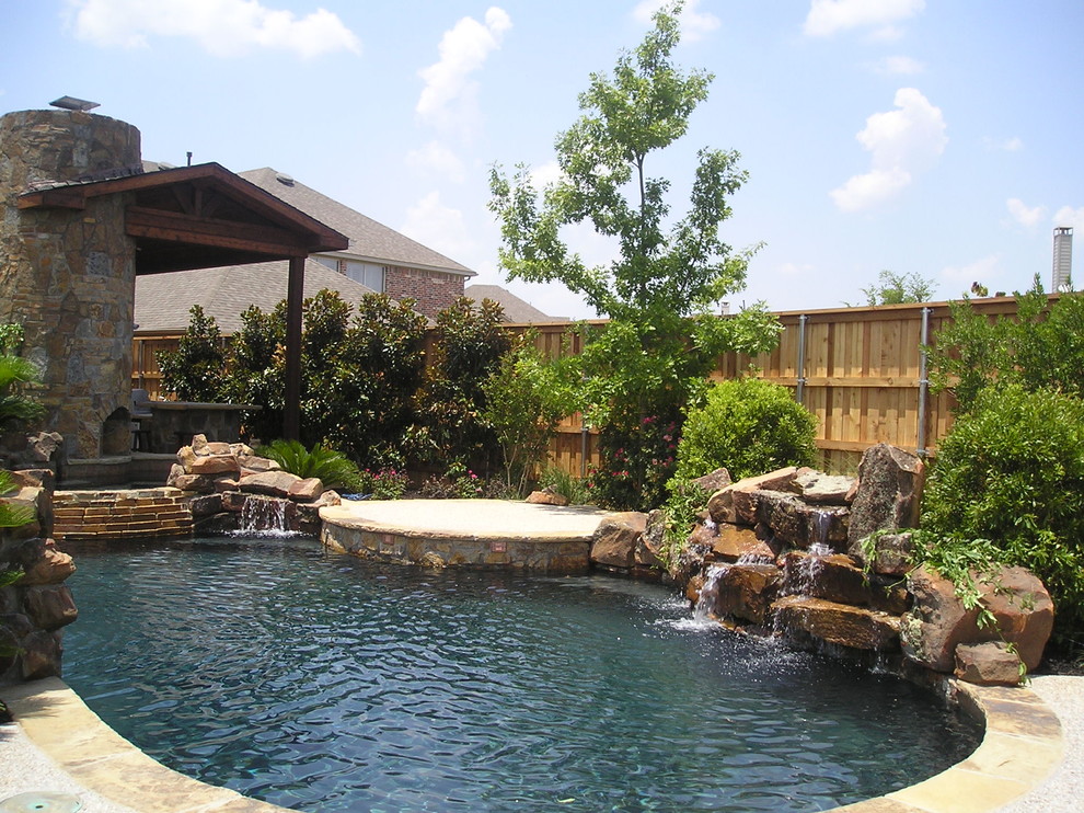 Mid-sized mediterranean backyard custom-shaped natural pool in Dallas with a water feature and natural stone pavers.