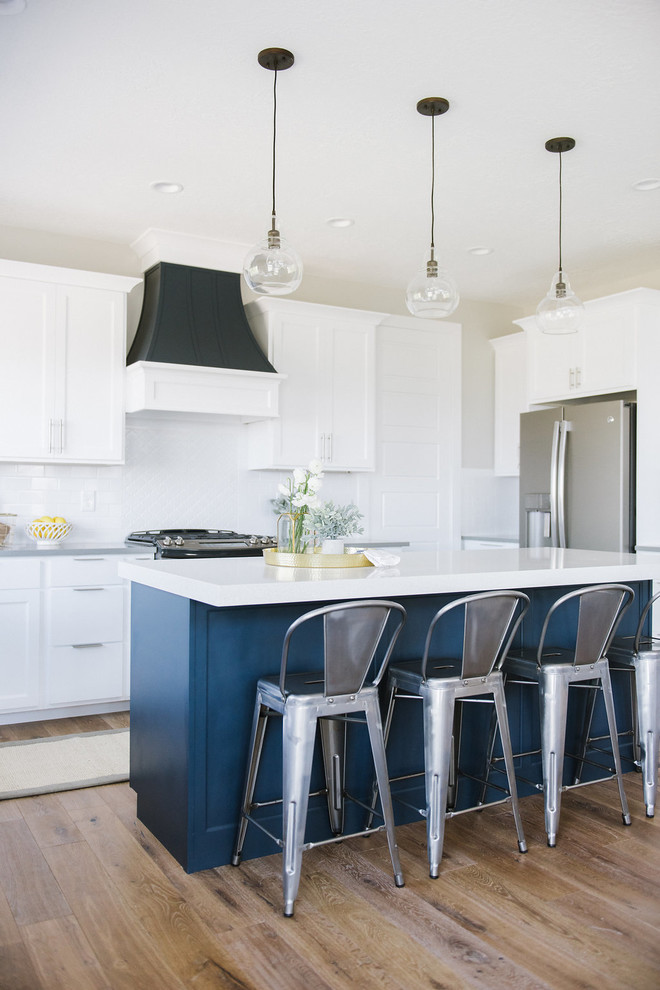 Inspiration for a country kitchen in Salt Lake City with shaker cabinets, white cabinets, white splashback, stainless steel appliances, dark hardwood floors and with island.