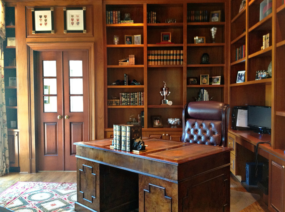 This is an example of a mid-sized traditional study room in Tampa with brown walls, dark hardwood floors, no fireplace, a freestanding desk and brown floor.