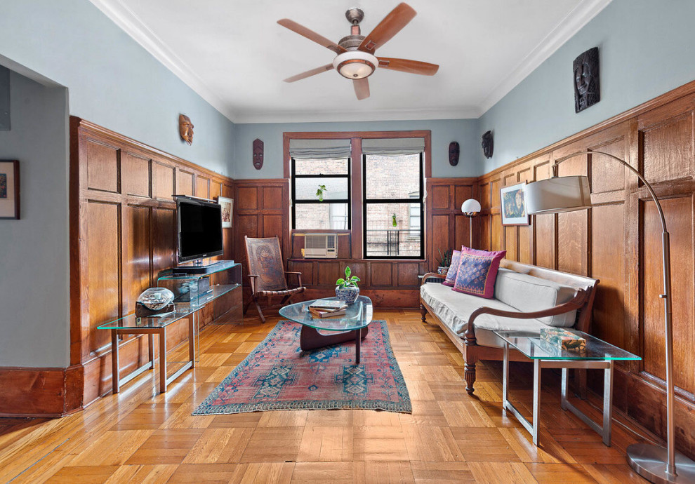 Diseño de salón cerrado de estilo americano de tamaño medio con paredes grises, suelo marrón y panelado