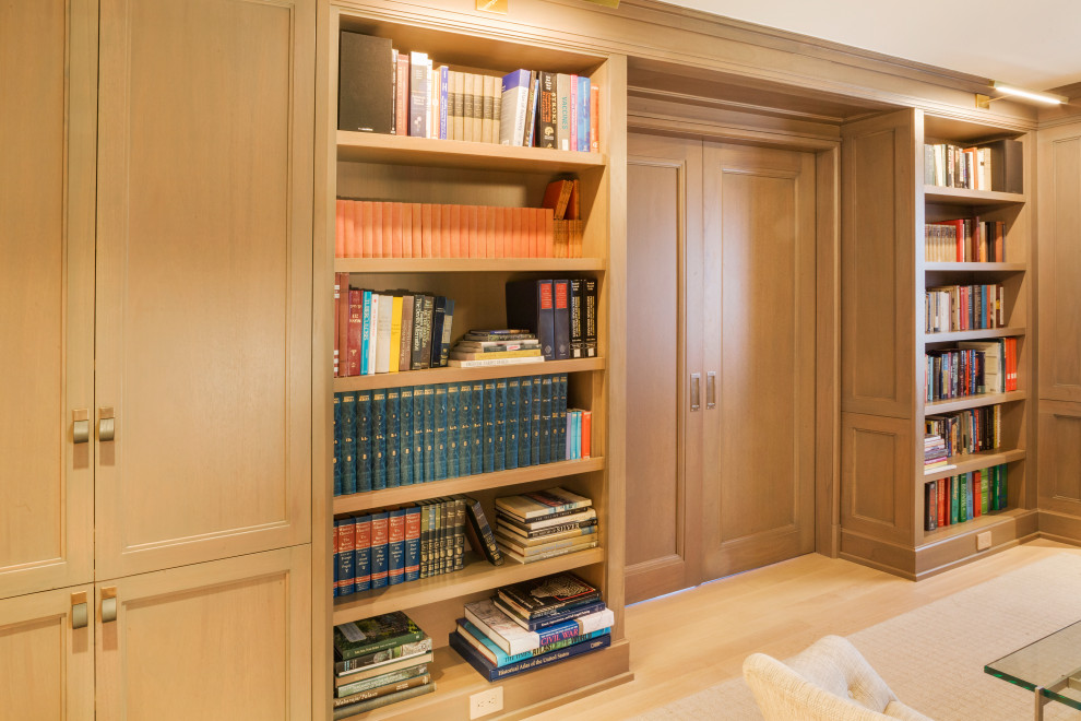 Cette photo montre une salle de séjour moderne en bois de taille moyenne et fermée avec une bibliothèque ou un coin lecture, un mur beige, parquet clair et un sol beige.