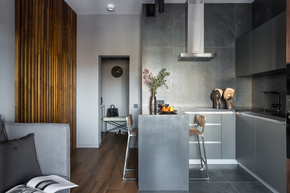 Inspiration for a small contemporary u-shaped open plan kitchen in Saint Petersburg with flat-panel cabinets, grey cabinets, solid surface benchtops, grey splashback, porcelain splashback, stainless steel appliances, porcelain floors, a peninsula, black floor and black benchtop.