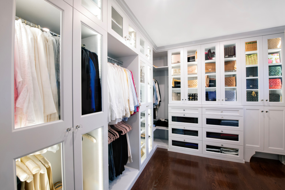 This is an example of a mid-sized traditional women's dressing room in Philadelphia with shaker cabinets, white cabinets, dark hardwood floors and brown floor.