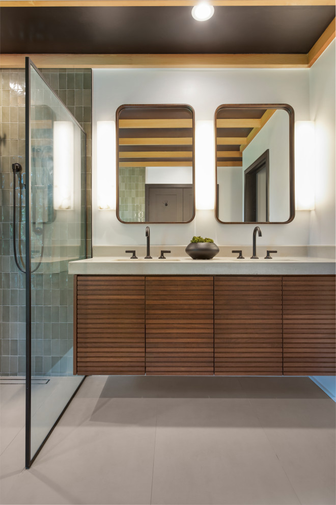 This is an example of a large contemporary bathroom in Los Angeles with medium wood cabinets, a freestanding tub, a bidet, green tile, porcelain tile, white walls, porcelain floors, an integrated sink, concrete benchtops, grey floor, grey benchtops, a niche, a double vanity, a floating vanity and wood.