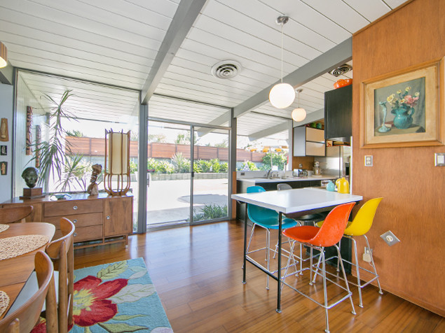 Design ideas for a mid-sized midcentury kitchen/dining combo in Orange County with white walls, medium hardwood floors and no fireplace.