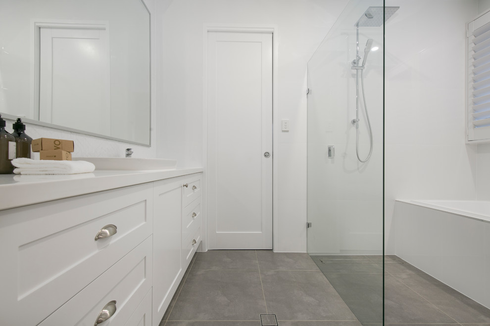 Inspiration for a large contemporary kids bathroom in Brisbane with shaker cabinets, white cabinets, a corner shower, a two-piece toilet, porcelain tile, white walls, an integrated sink, an open shower, a drop-in tub, ceramic floors, engineered quartz benchtops and grey floor.