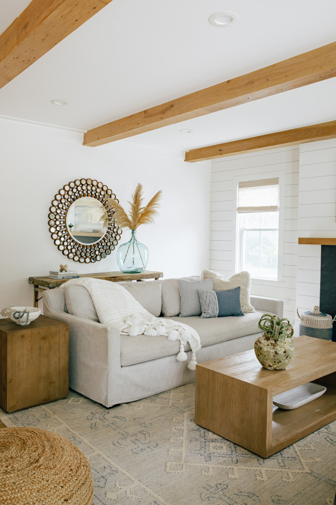 Photo of a large beach style open concept living room in Other with white walls, light hardwood floors, a standard fireplace, a concrete fireplace surround, a wall-mounted tv, brown floor, exposed beam and planked wall panelling.