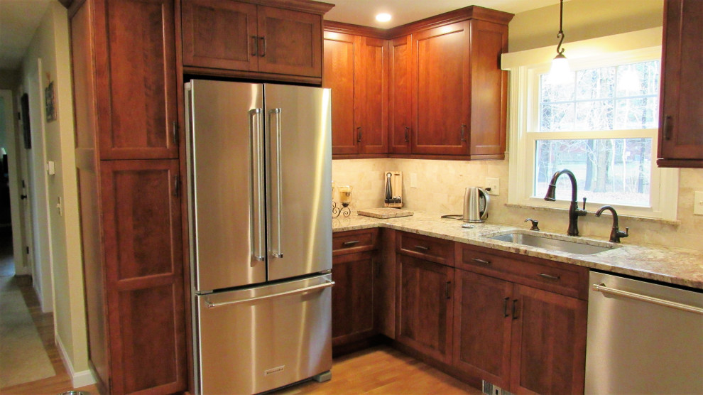 Example of a mid-sized transitional u-shaped light wood floor and brown floor enclosed kitchen design in Boston with an undermount sink, recessed-panel cabinets, brown cabinets, granite countertops, beige backsplash, stainless steel appliances, no island and beige countertops