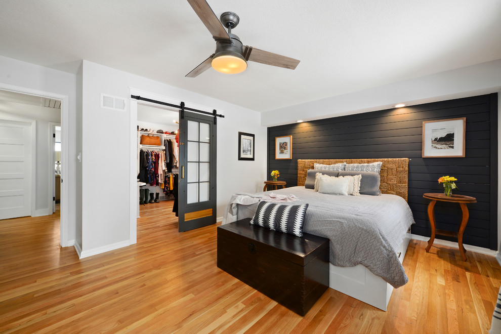 This is an example of a small traditional master bedroom in Kansas City with white walls and medium hardwood floors.
