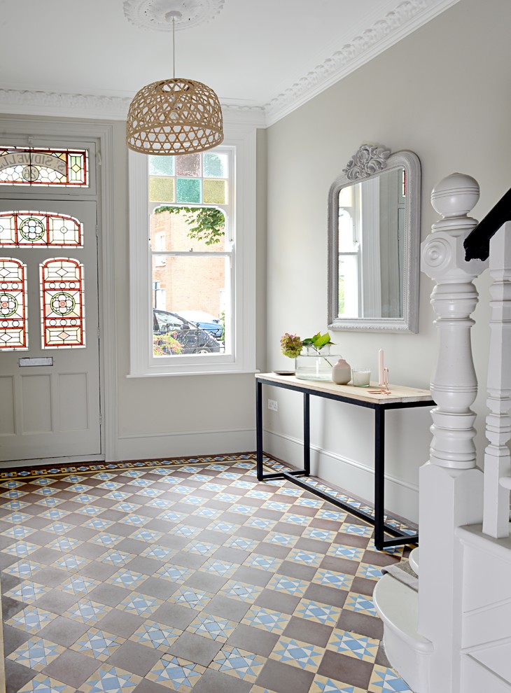Traditional foyer in London with grey walls, terra-cotta floors, a single front door and a white front door.