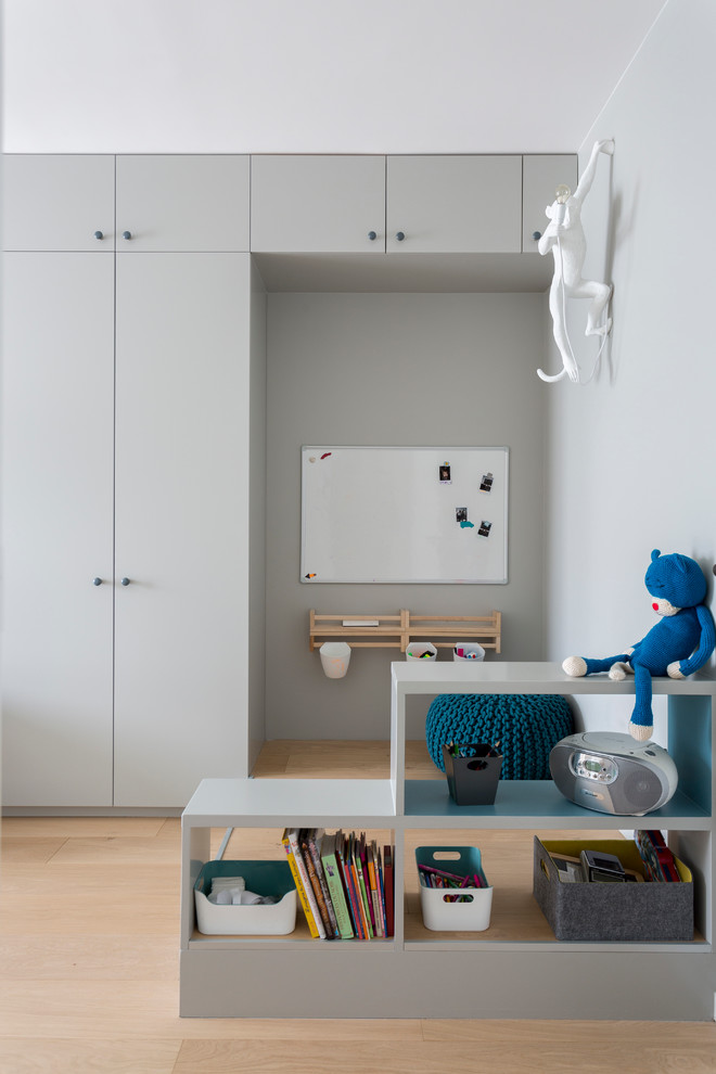 Photo of a mid-sized contemporary kids' bedroom for kids 4-10 years old and boys in Paris with multi-coloured walls and light hardwood floors.