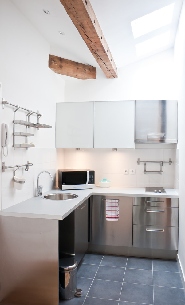 Small contemporary l-shaped separate kitchen in Paris with a single-bowl sink, flat-panel cabinets, stainless steel cabinets, white splashback, stainless steel appliances and no island.