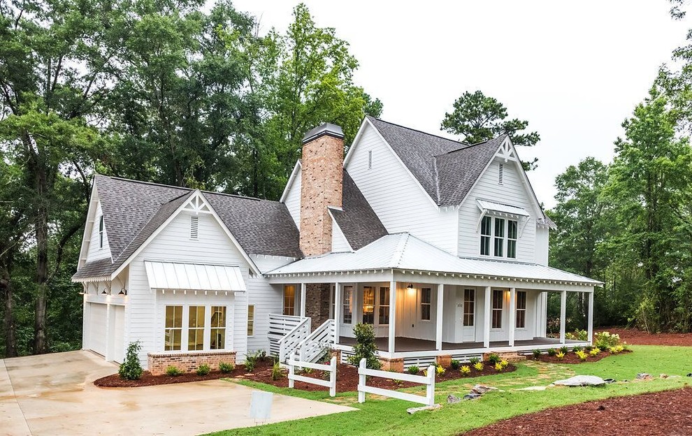 Large country two-storey white house exterior in Atlanta with vinyl siding, a hip roof and a shingle roof.