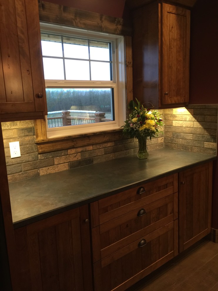 Inspiration for a mid-sized rustic eat-in kitchen remodel in Edmonton with a double-bowl sink, shaker cabinets, medium tone wood cabinets, laminate countertops, subway tile backsplash, black appliances and an island