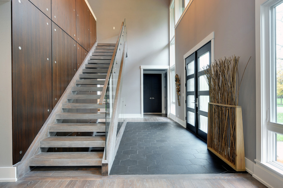 Photo of a large contemporary wood straight staircase in Chicago with open risers.
