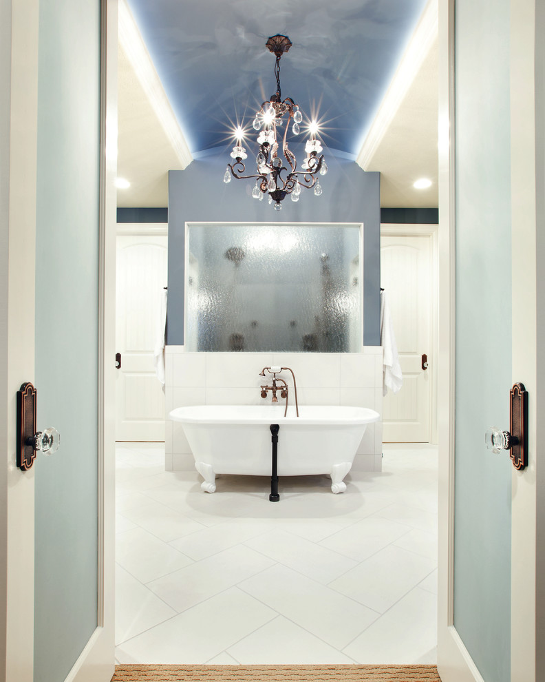 Photo of a traditional bathroom in Omaha with a claw-foot tub and white floor.