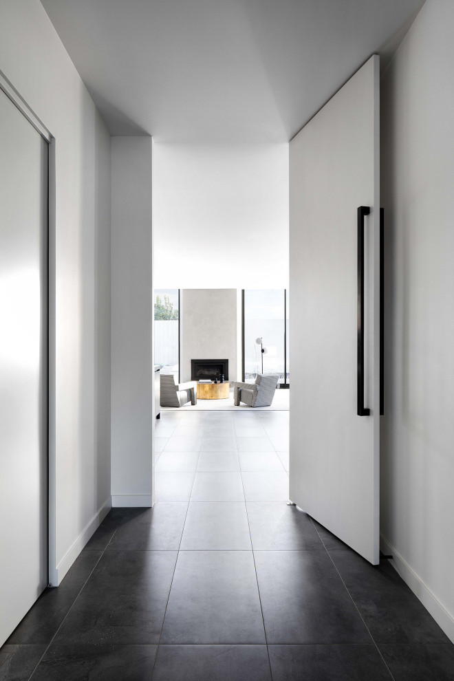 Inspiration pour un couloir design avec un sol en carrelage de porcelaine et un sol gris.