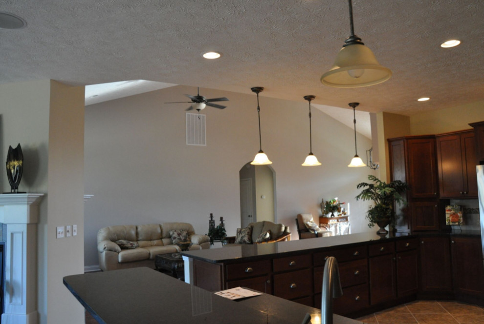 Example of a mid-sized classic l-shaped porcelain tile and beige floor open concept kitchen design with a double-bowl sink, shaker cabinets, brown cabinets, granite countertops, beige backsplash, porcelain backsplash and stainless steel appliances
