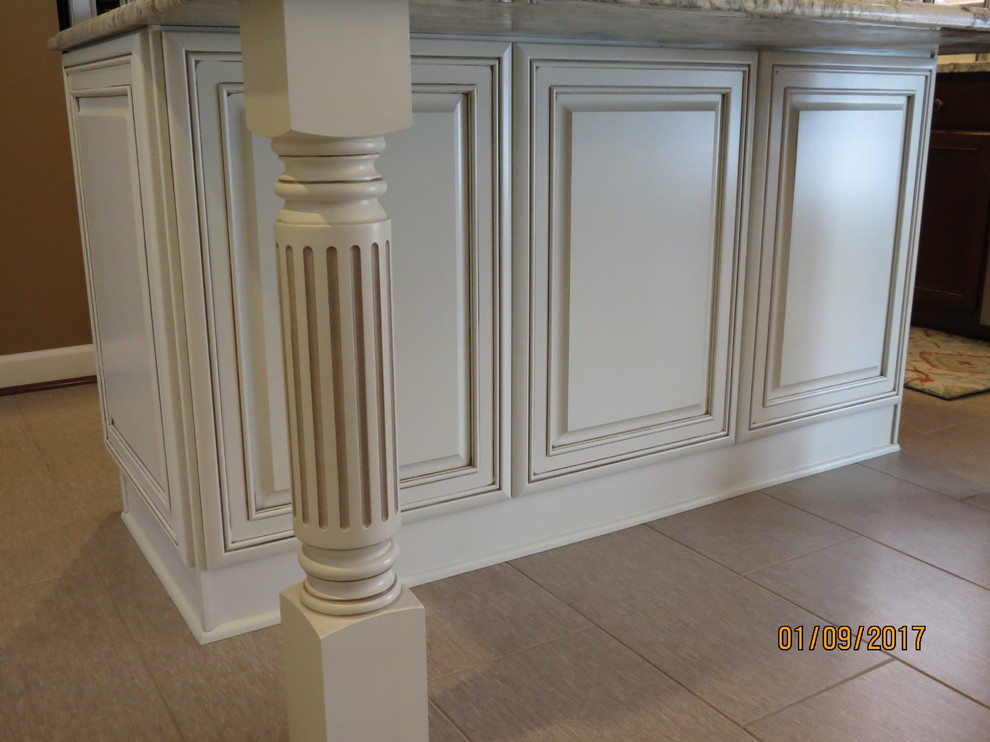 Eat-in kitchen - mid-sized transitional l-shaped ceramic tile eat-in kitchen idea with an undermount sink, raised-panel cabinets, distressed cabinets, granite countertops, white backsplash, porcelain backsplash, stainless steel appliances and an island