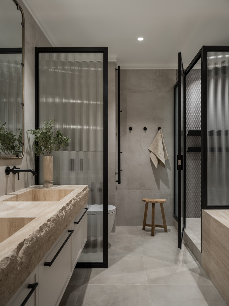 Photo of a classic ensuite bathroom in Other with shaker cabinets, white cabinets, an alcove shower, grey tiles, an integrated sink, grey floors, beige worktops, double sinks and a floating vanity unit.