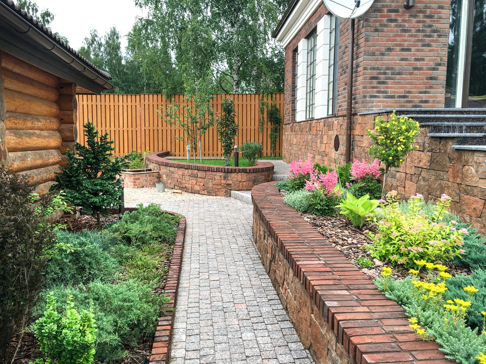 Design ideas for a traditional garden for summer in Saint Petersburg with a retaining wall.