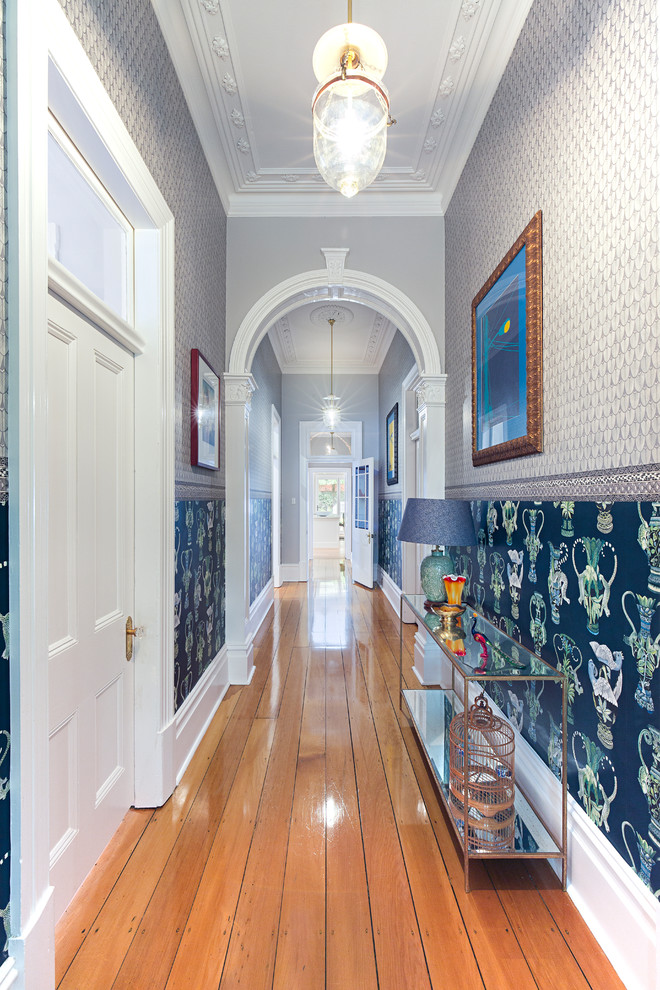 Inspiration for an eclectic hallway in Sydney with multi-coloured walls, medium hardwood floors and brown floor.