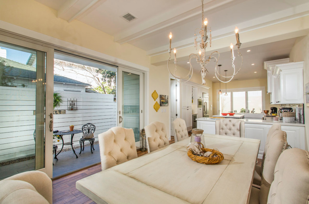 Inspiration for a mid-sized beach style open plan dining in San Diego with yellow walls, dark hardwood floors, no fireplace and brown floor.