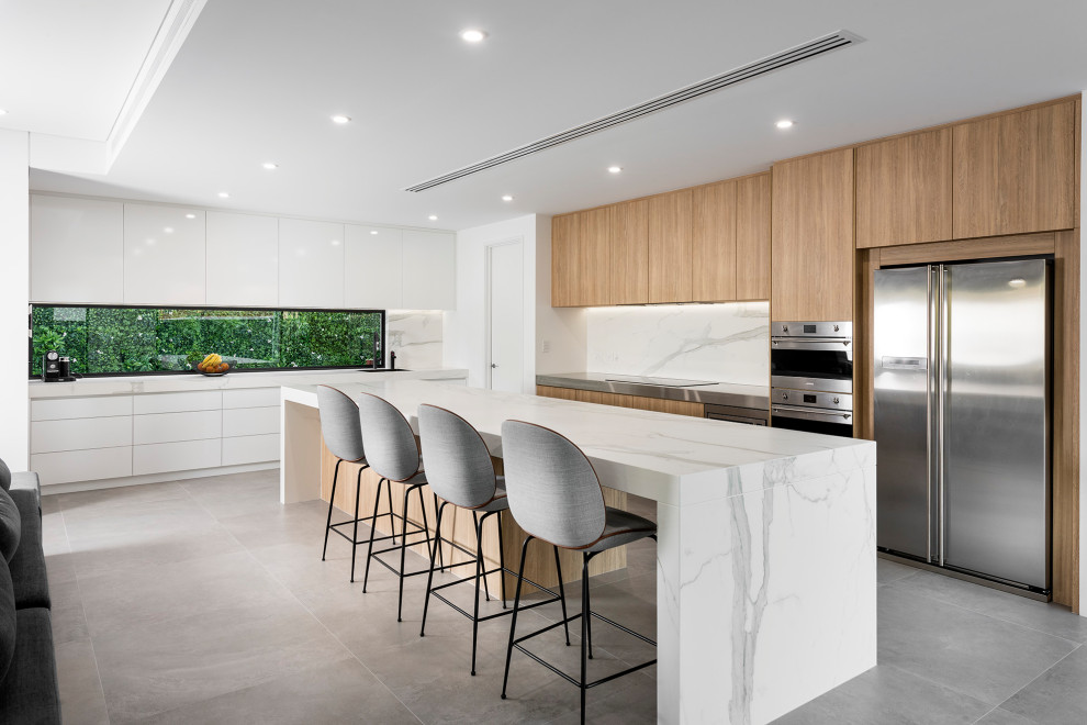 This is an example of an expansive modern kitchen in Perth with a submerged sink, engineered stone countertops, white splashback, engineered quartz splashback, stainless steel appliances, porcelain flooring, an island, grey floors and white worktops.
