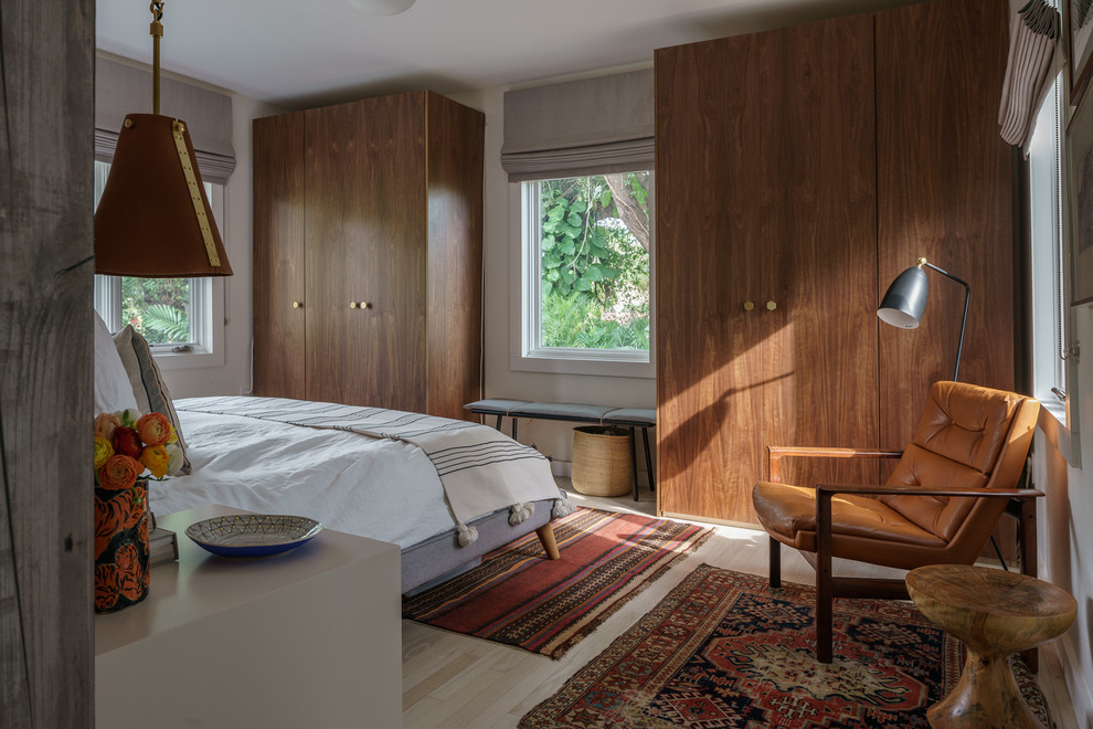 This is an example of a midcentury bedroom in Miami with white walls, light hardwood floors and beige floor.
