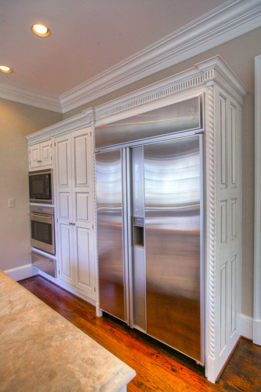Inspiration for a mid-sized transitional l-shaped medium tone wood floor eat-in kitchen remodel in Charlotte with an island, an undermount sink, raised-panel cabinets, white cabinets, marble countertops, multicolored backsplash, stone slab backsplash and stainless steel appliances