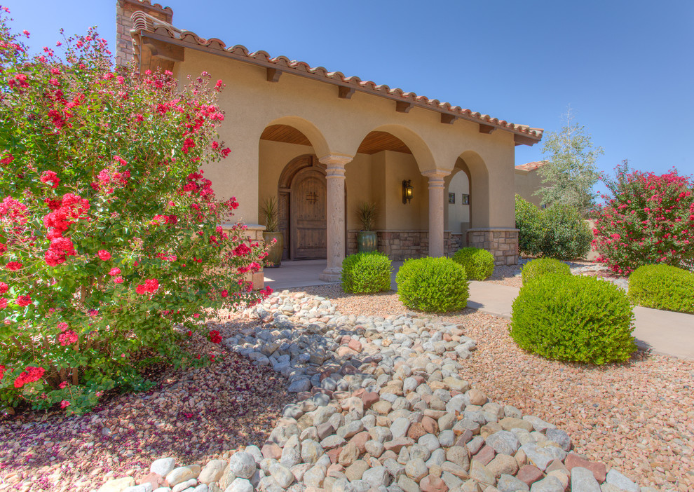 Photo of a one-storey beige exterior in Albuquerque with stone veneer and a flat roof.