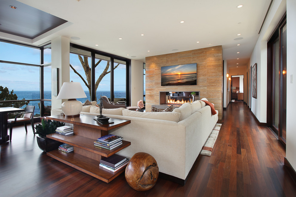 Large contemporary open concept family room in Orange County with a two-sided fireplace and white walls.