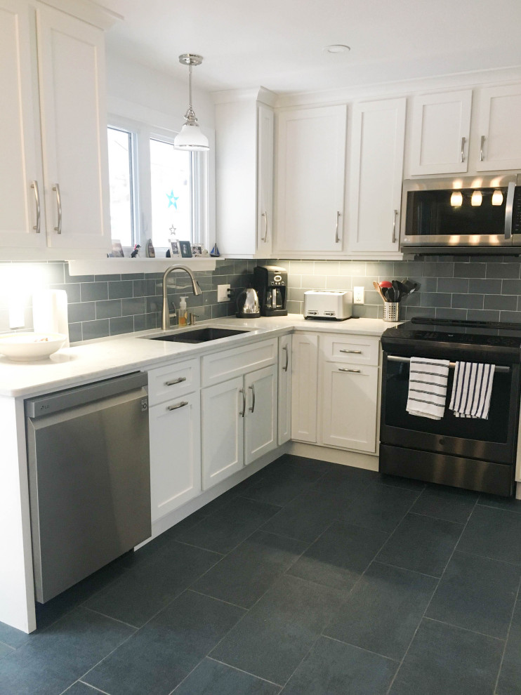 Mid-sized transitional l-shaped porcelain tile and gray floor enclosed kitchen photo with an undermount sink, shaker cabinets, white cabinets, granite countertops, gray backsplash, subway tile backsplash, stainless steel appliances, no island and white countertops