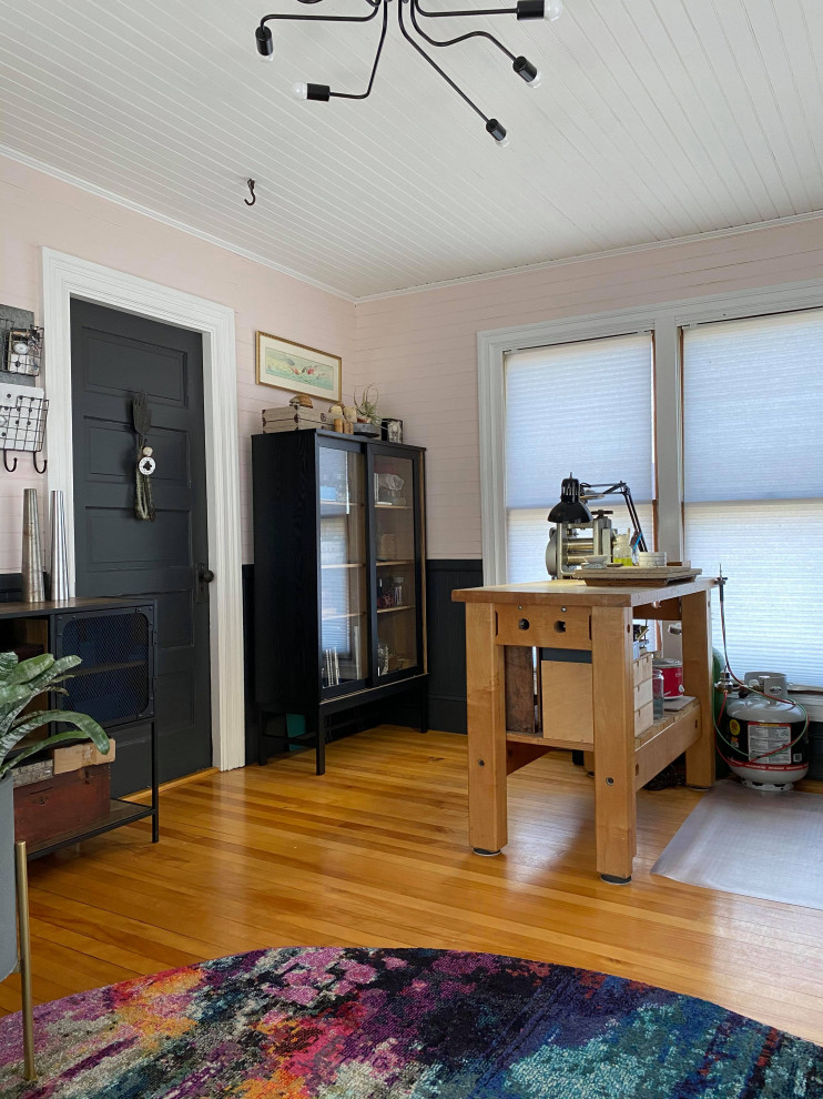 Idéer för små industriella hemmastudior, med rosa väggar, mellanmörkt trägolv och ett fristående skrivbord