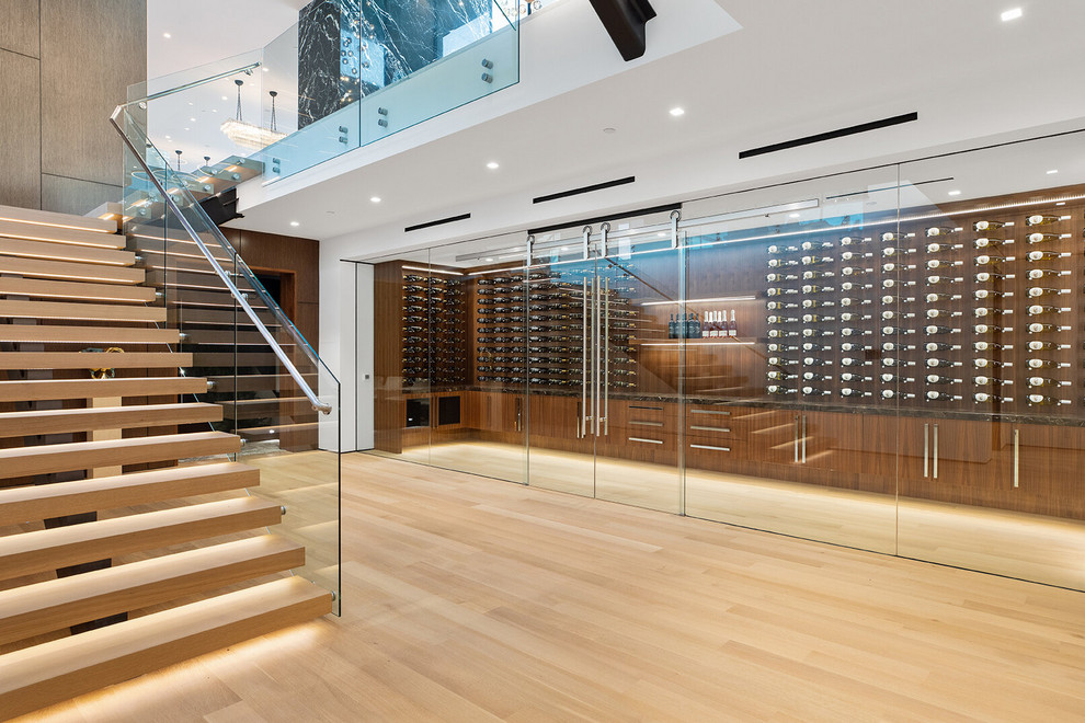Photo of a contemporary wine cellar in Los Angeles with display racks, light hardwood floors and beige floor.