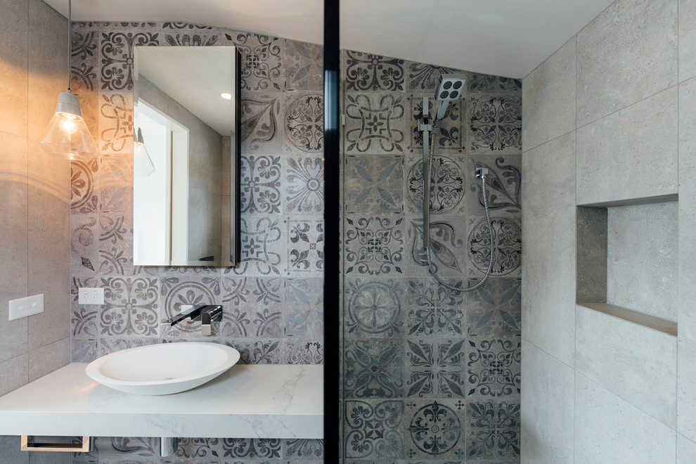 Design ideas for a mid-sized contemporary master bathroom in Sydney with a freestanding tub, an open shower, gray tile, stone tile, grey walls, cement tiles, a vessel sink and marble benchtops.
