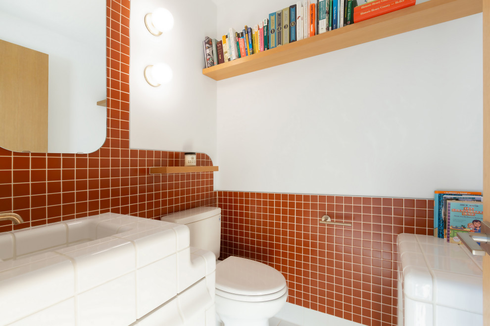 Inspiration för ett funkis vit vitt badrum med dusch, med vita skåp, en toalettstol med hel cisternkåpa, röd kakel, porslinskakel, vita väggar, klinkergolv i porslin, ett integrerad handfat, kaklad bänkskiva och vitt golv