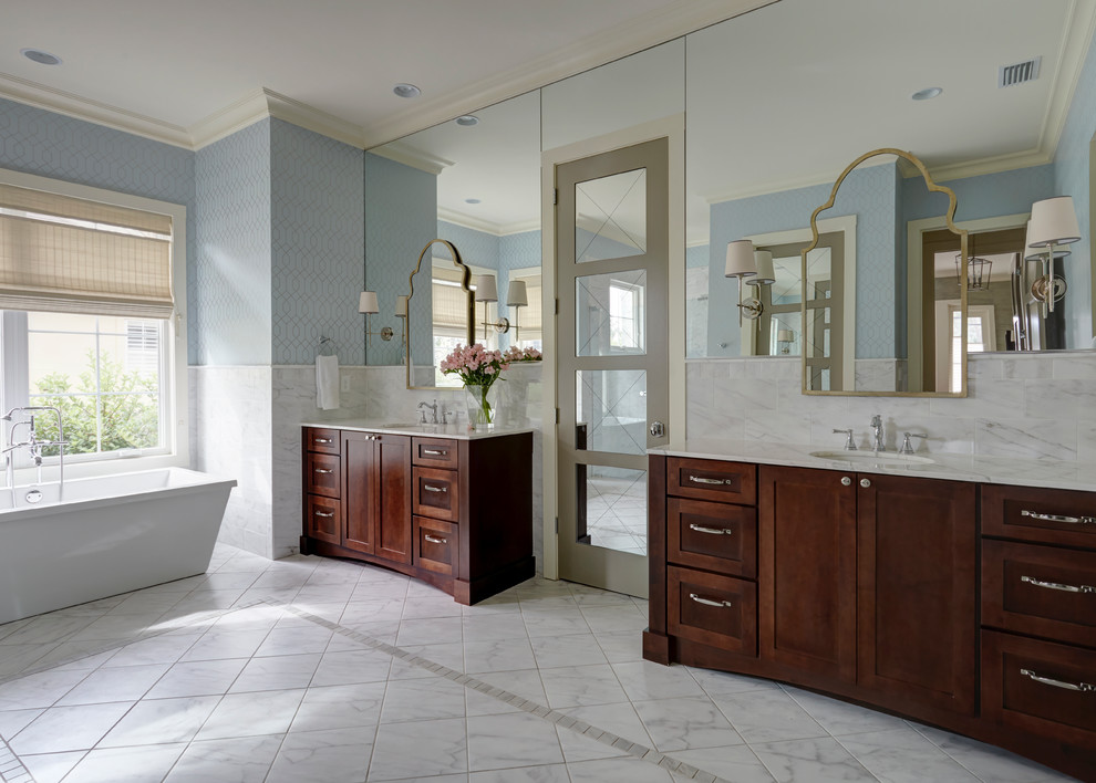 This is an example of a large transitional master bathroom in Jacksonville with shaker cabinets, brown cabinets, an alcove shower, a two-piece toilet, white tile, blue walls, porcelain floors, marble benchtops and an undermount sink.