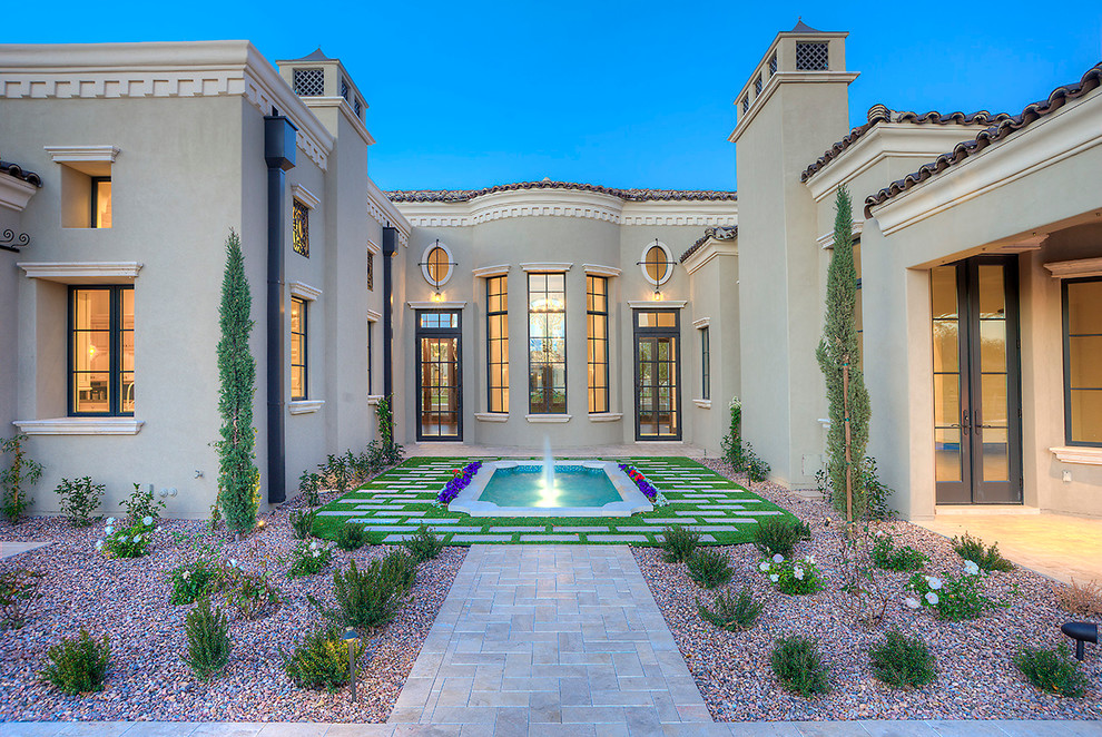 Expansive mediterranean backyard patio in Phoenix with a water feature, no cover and natural stone pavers.