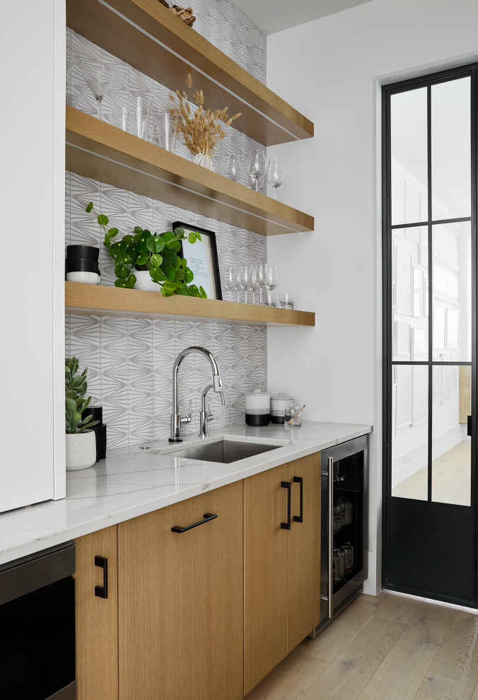 Design ideas for a modern kitchen pantry in Chicago with flat-panel cabinets, light wood cabinets, quartz benchtops, white splashback, engineered quartz splashback, light hardwood floors, with island and white benchtop.